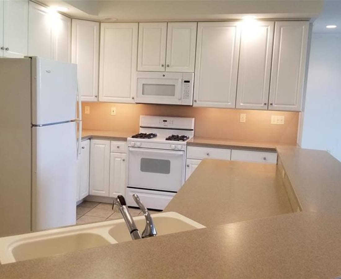 Fully equipped kitchen with white cabinetry at Springhouse Townhomes in Allentown, Pennsylvania