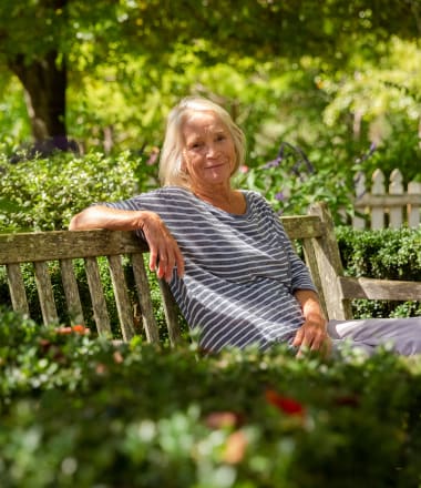 Resident hanging out on park bench near Mirror Lake Village Senior Living Community in Federal Way, Washington.