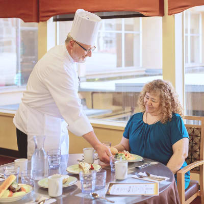 Chef presenting a delicious, fresh-made meal to a resident at Cascade Park Vista Assisted Living in Tacoma, Washington