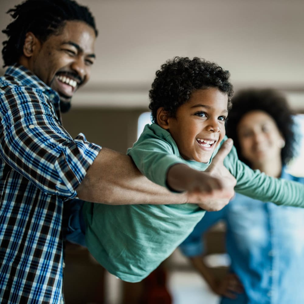 Family having fun together in their new home at Oaks 5th Street Crossing At City Center in Garland, Texas