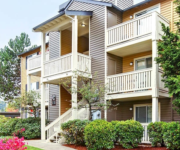 Exterior building view with walkway and landscaping at Newport Crossing Apartments in Newcastle