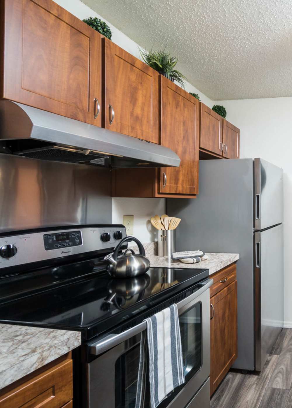 Modern kitchen with wooden cabinets at Paddock Club Apartments in Florence, Kentucky