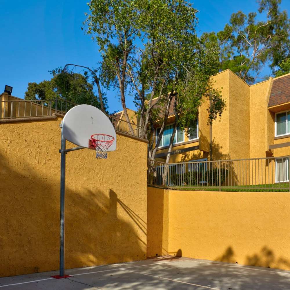 Basket ball court with hoop on the other side at St. Andrews Gardens in Los Angeles, California