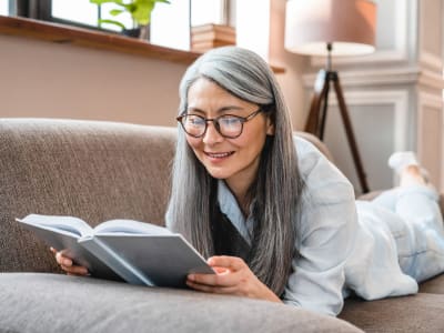 Resident reading a book at the library near Hudson Oaks Active Adult Living in Bryan, Texas