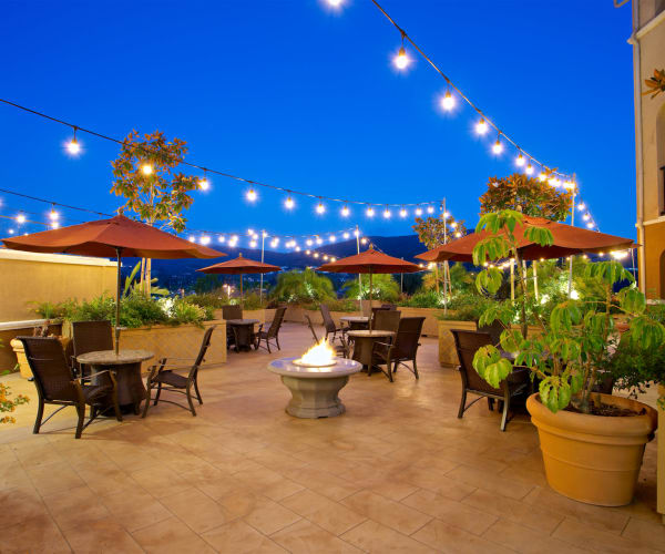 Outdoor dining area with string lighting at Meridian at Lake San Marcos in San Marcos, California