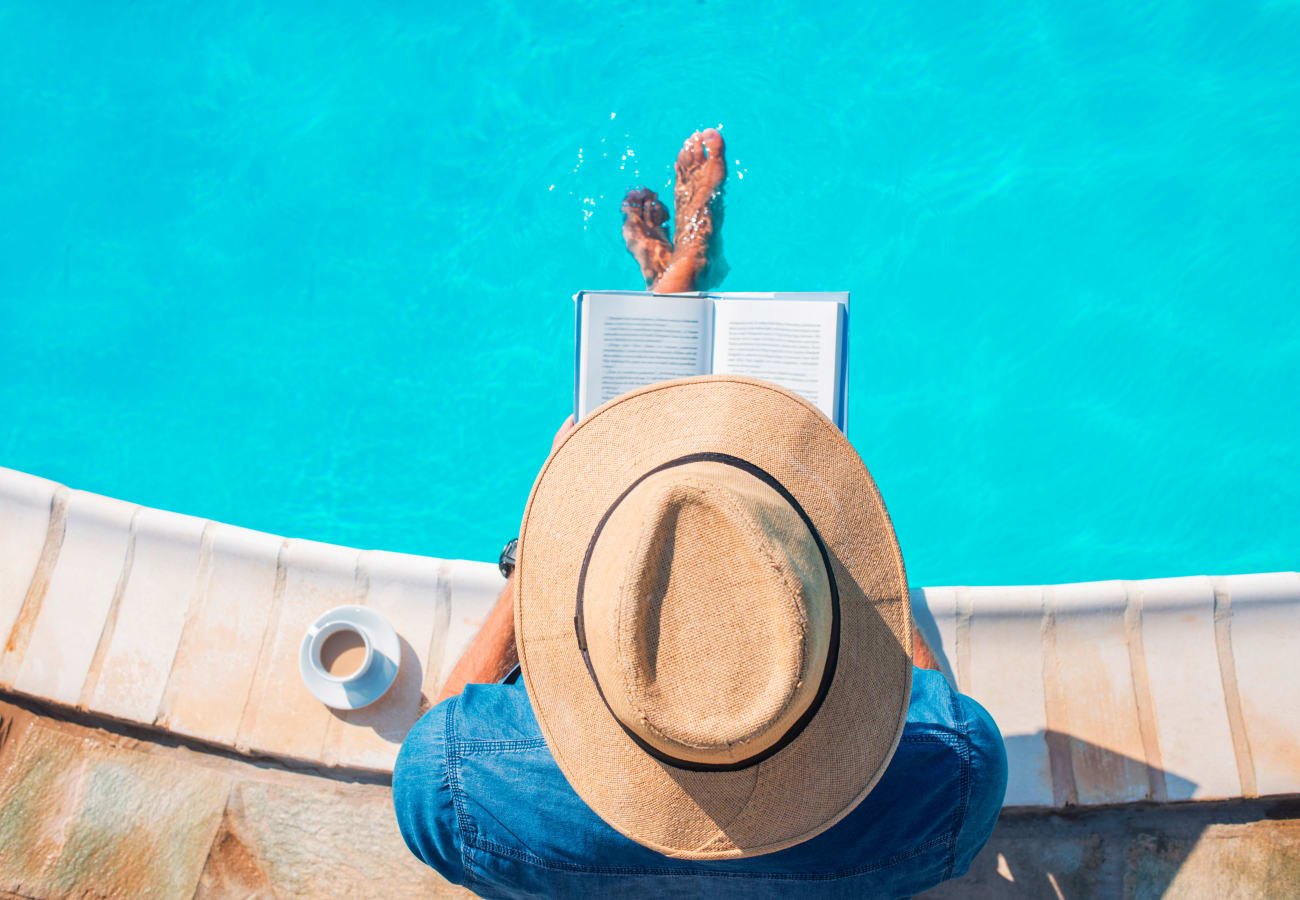 Resident reading by the swimming pool at Old Plantation in Riverside, California