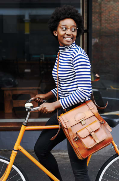 Woman walking her bike in Watertown, Massachusetts near Riverbend on the Charles