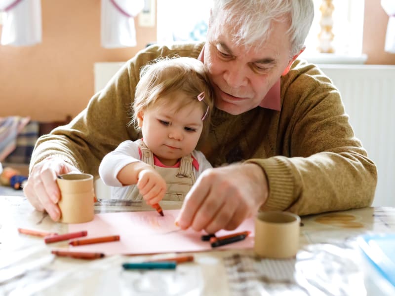 Resident working on a drawing with a young family member at a WISH community