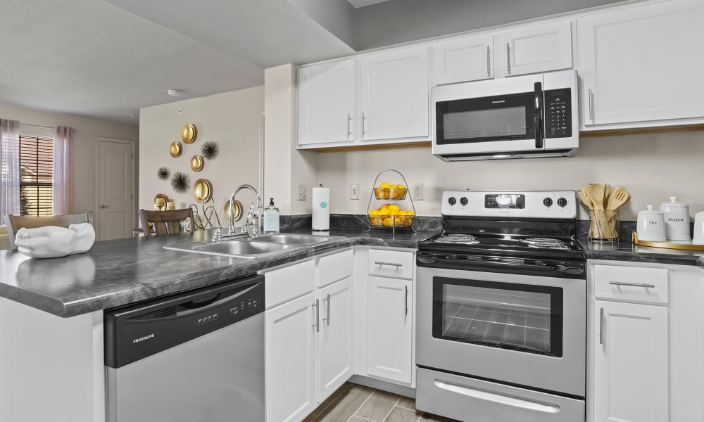 Spacious kitchen with granite countertops and light cabinetry at Watercress Apartments in Maize, Kansas