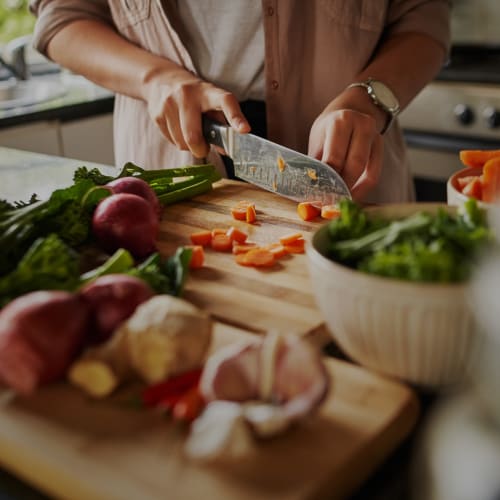 A resident chopping vegetables at Home Terrace in San Diego, California