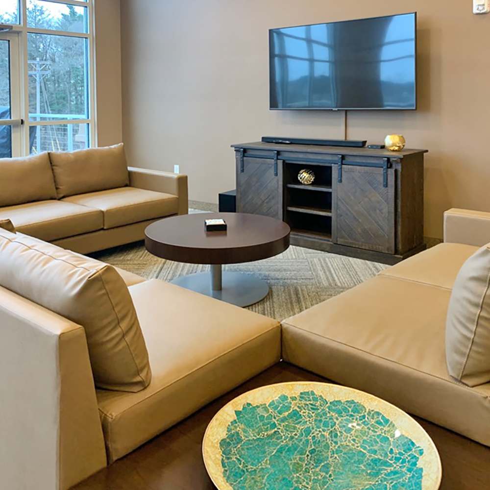 Clubhouse with large couch and flat screen television at Depot on Main in Zimmerman, Minnesota