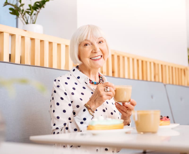 Woman sitting in a cafe booth drinking coffee at York Gardens in Edina, Minnesota