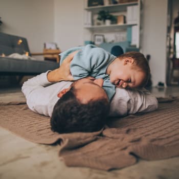 A family playing on the floor of their apartment at Brookwood Apartments in Indianapolis, Indiana