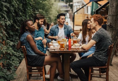 Resident friends having food and drinks at their favorite spot near Timber Lakes Apartment Homes in Kansas City, Missouri
