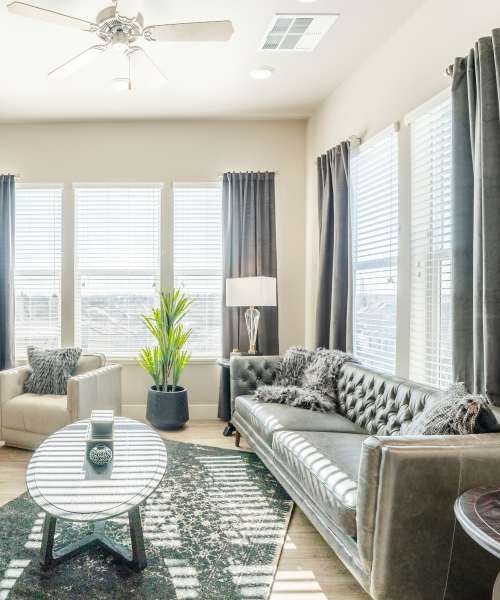 Living room with ceiling fan at Alira Apartments in Sacramento, California