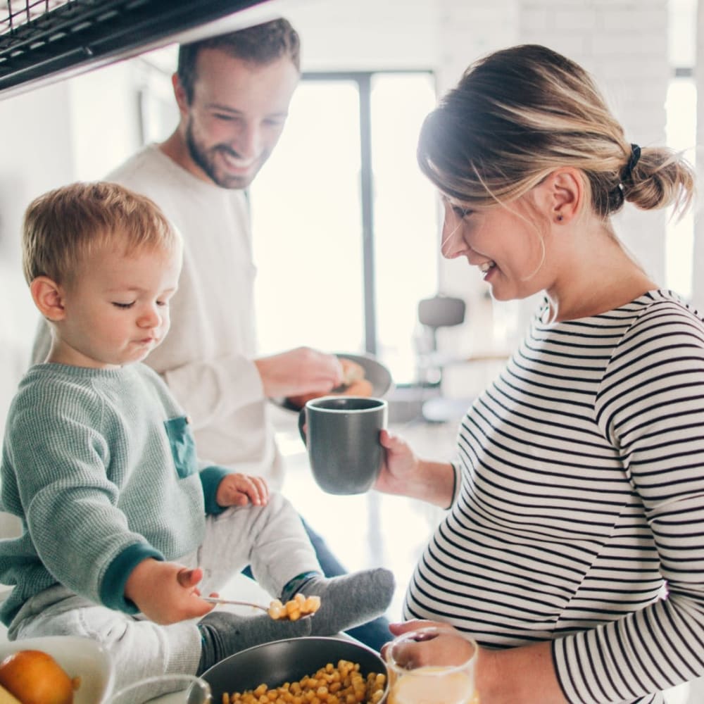 Family preparing breakfast together in their apartment's kitchen at Oaks 5th Street Crossing at City Station in Garland, Texas