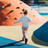 Child playing at a playground near Millennium Place in Corinth, Texas