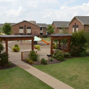 Aerial view of the courtyard with a playground and picnic area at Parkway Villas in Grand Prairie, Texas