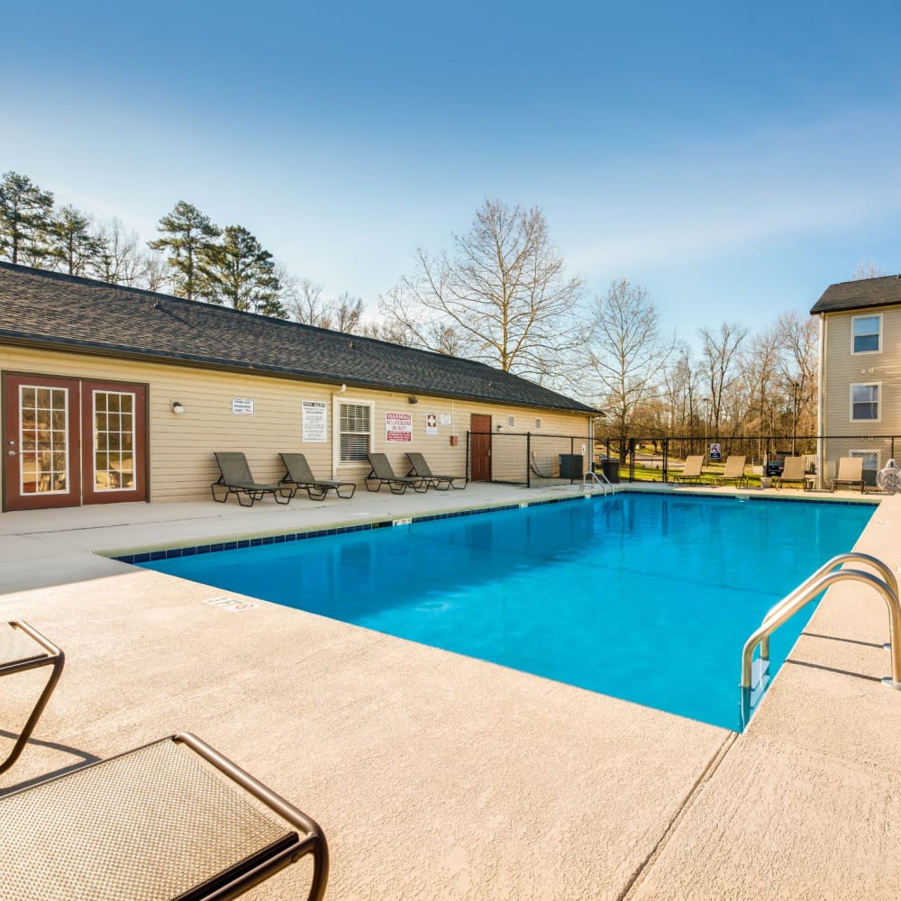 Swimming pool surrounded by lounge chairs at Alexander Station Apartment Homes in Salisbury, North Carolina