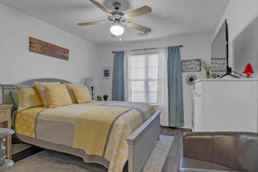 Comfortable bedroom with king size bed, ceiling fan and large window at River Ridge in Sand Springs, Oklahoma