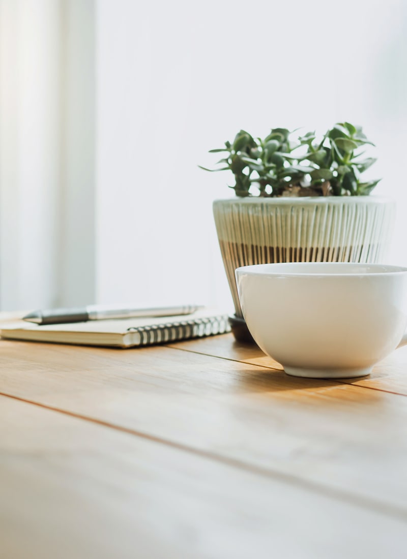 Notebook and coffee mug on table near plant at Marquis at Waterview in Richardson, Texas