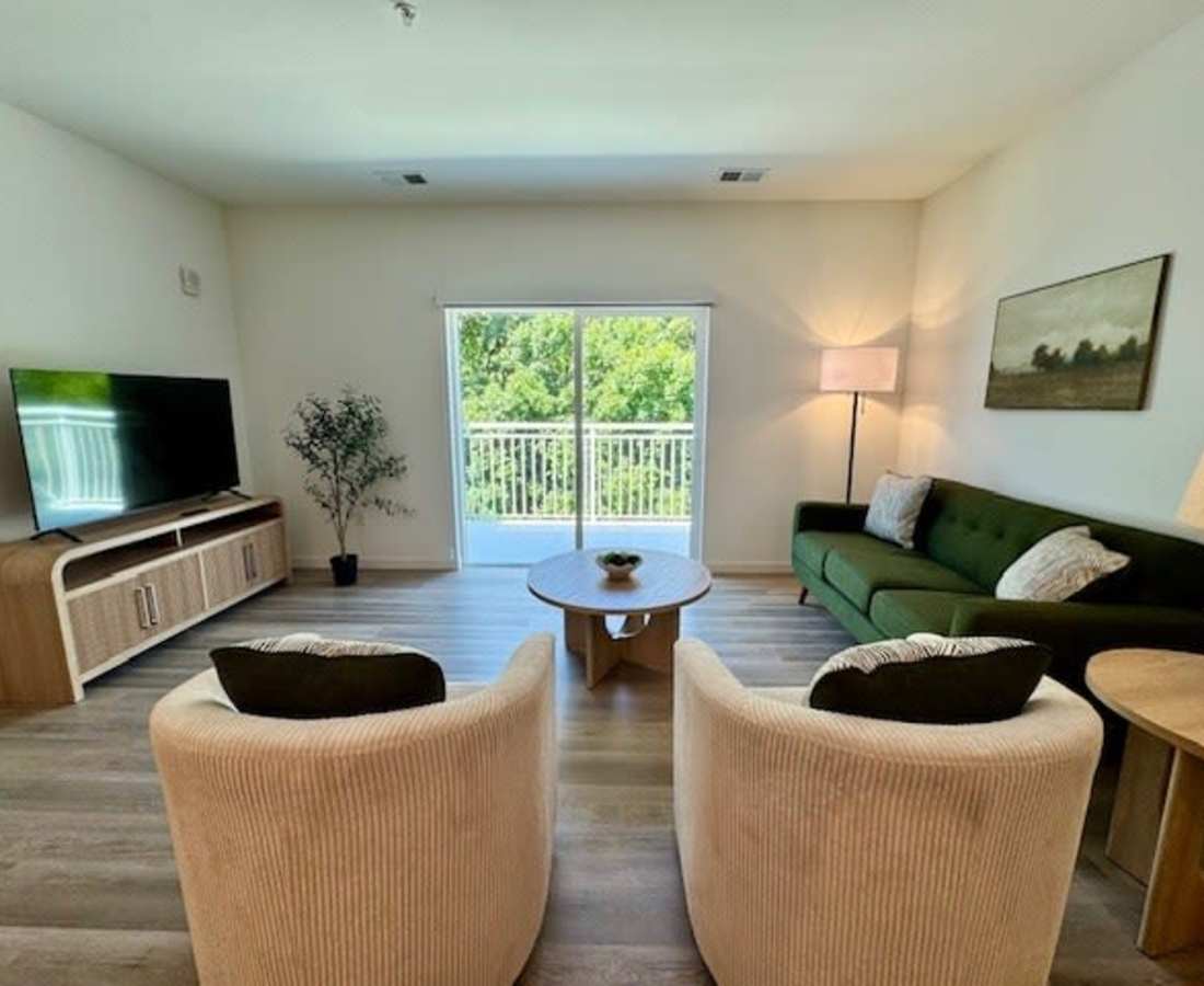 Green sofa with decorative pillows and lamp at Pritchard Park Place in Racine, Wisconsin