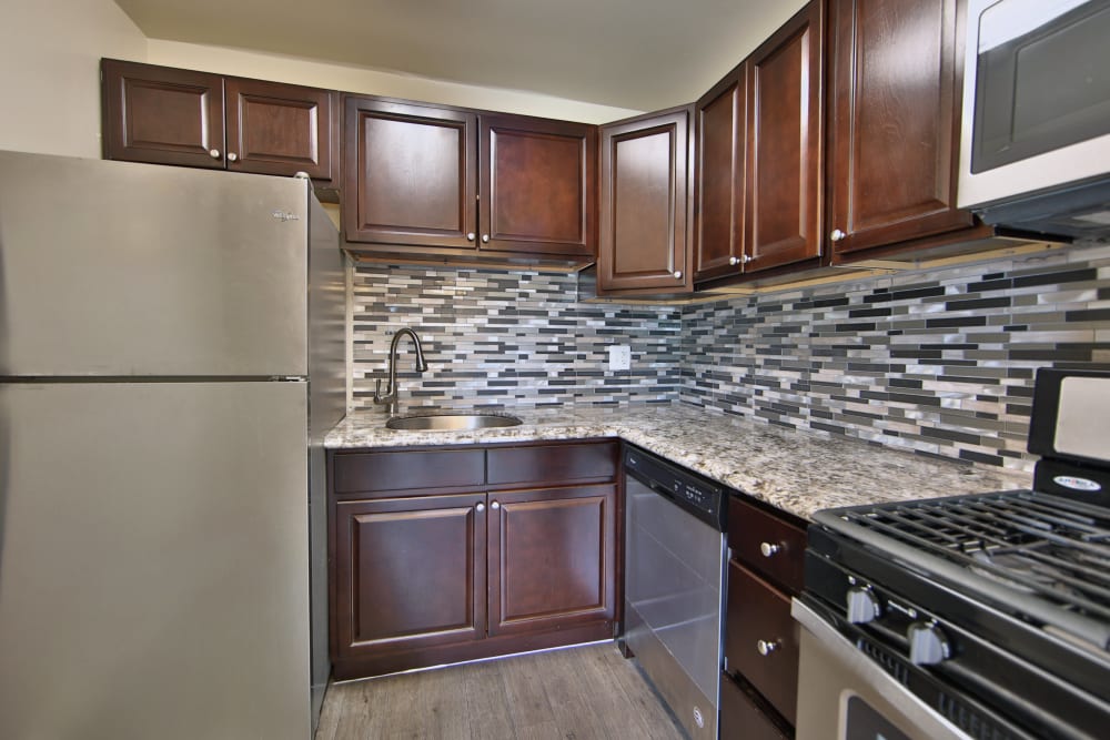 Kitchen with stainless-steel appliances and a tile backsplash at The Preserve at Owings Crossing Apartment Homes in Reisterstown, Maryland