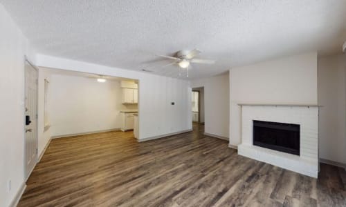 Apartment living room with wood-style flooring at The Haylie in Garland, Texas