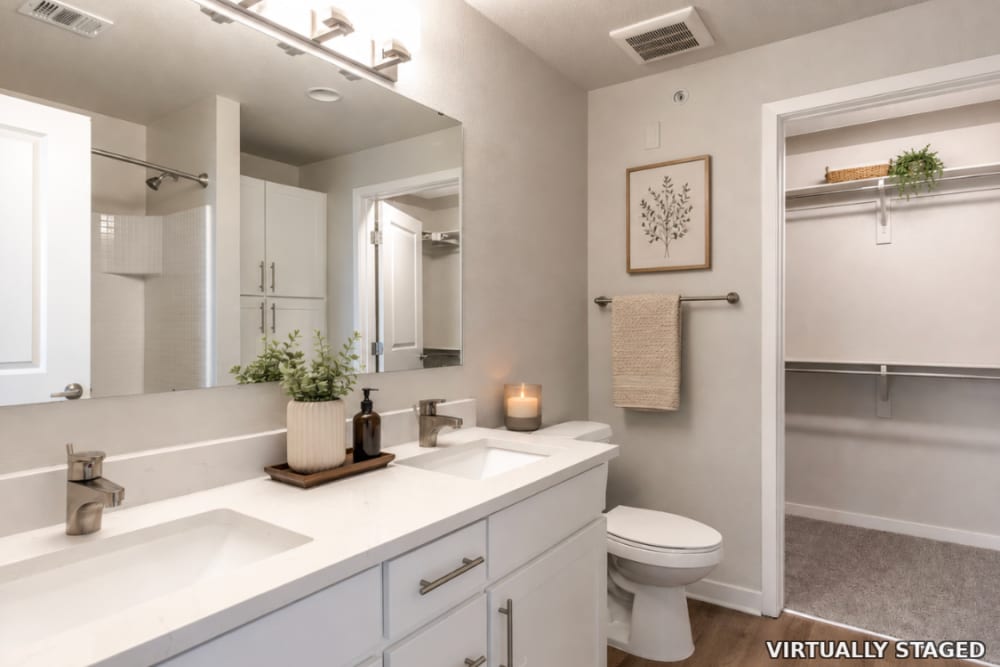 Dual sink vanity in the bathroom with access to the walk in closet at The Greens at Van de Water in Loveland, Colorado  