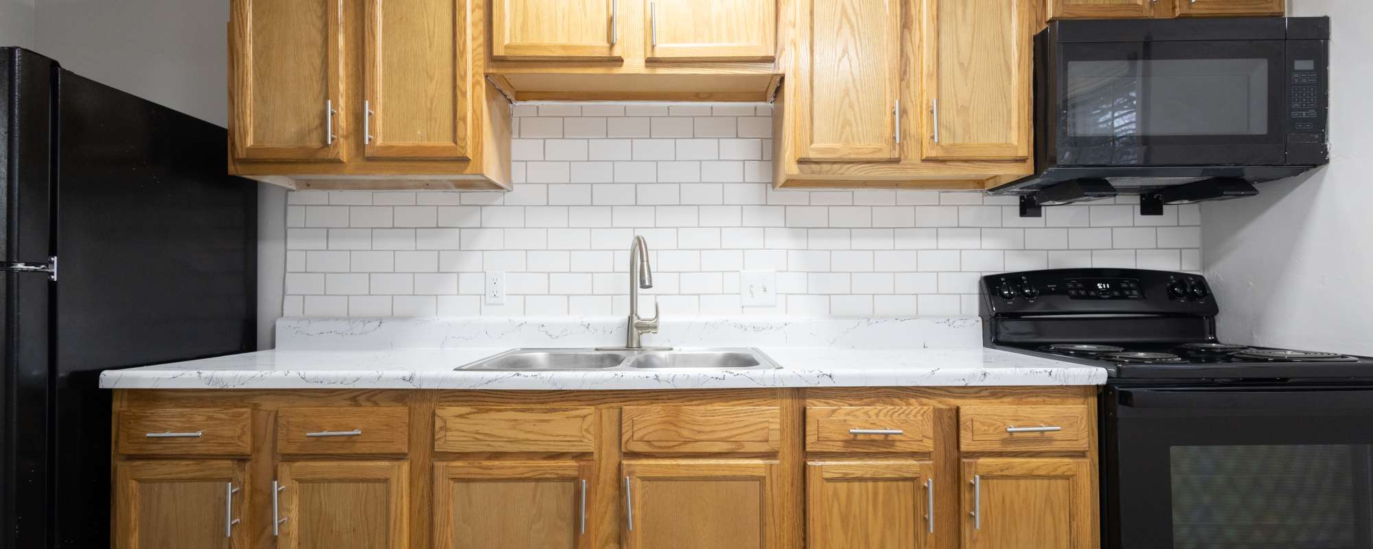 Kitchen with a stainless steel sink, oven, granite countertop and refrigerator at Fountain View Apartments in Indianapolis, Indiana