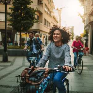 Three friends riding bikes along a lively urban street at Messina Luxury Apartments in New Smyrna Beach, Florida 