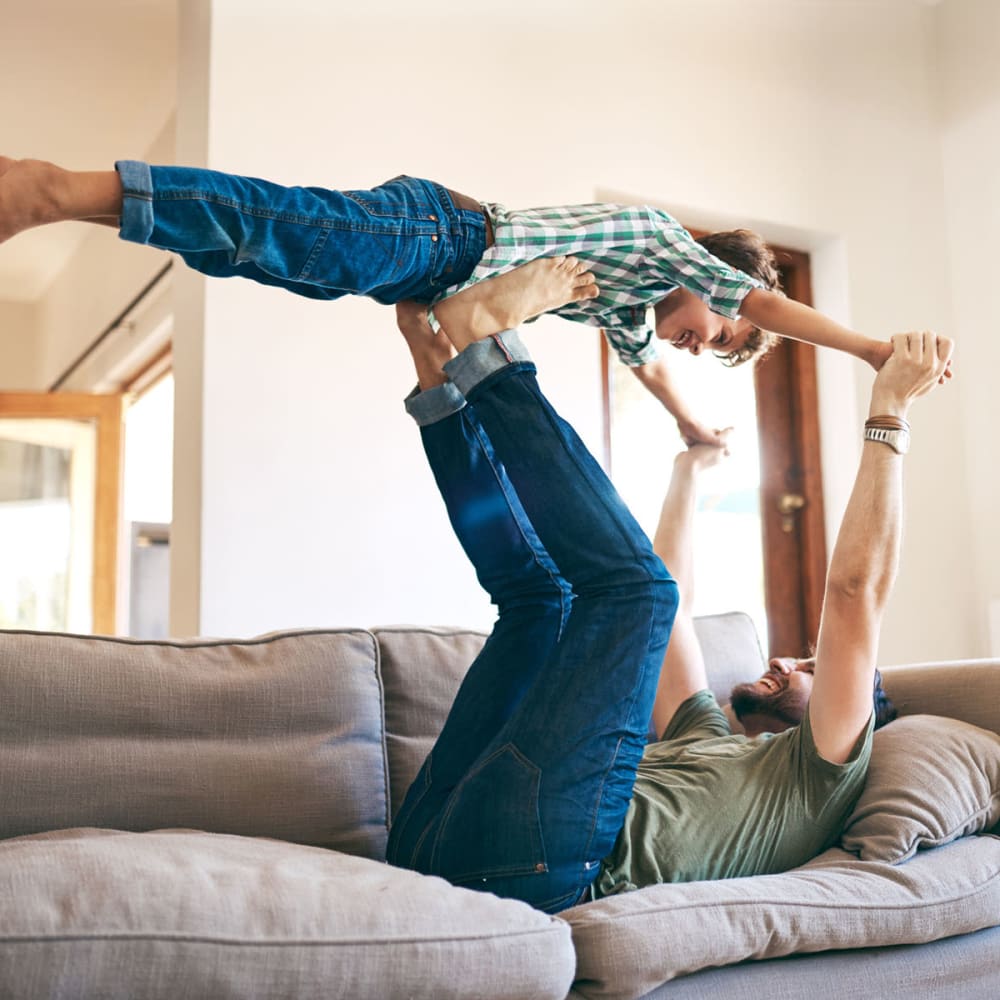 Father and son playing before school in the living area of their home at Oaks White Rock in Dallas, Texas