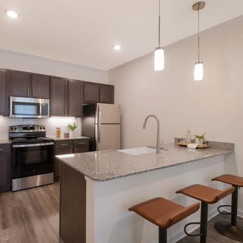 Stainless-steel appliances and breakfast bar in the kitchen at Reflection Pointe TN in Ooltewah, Tennessee