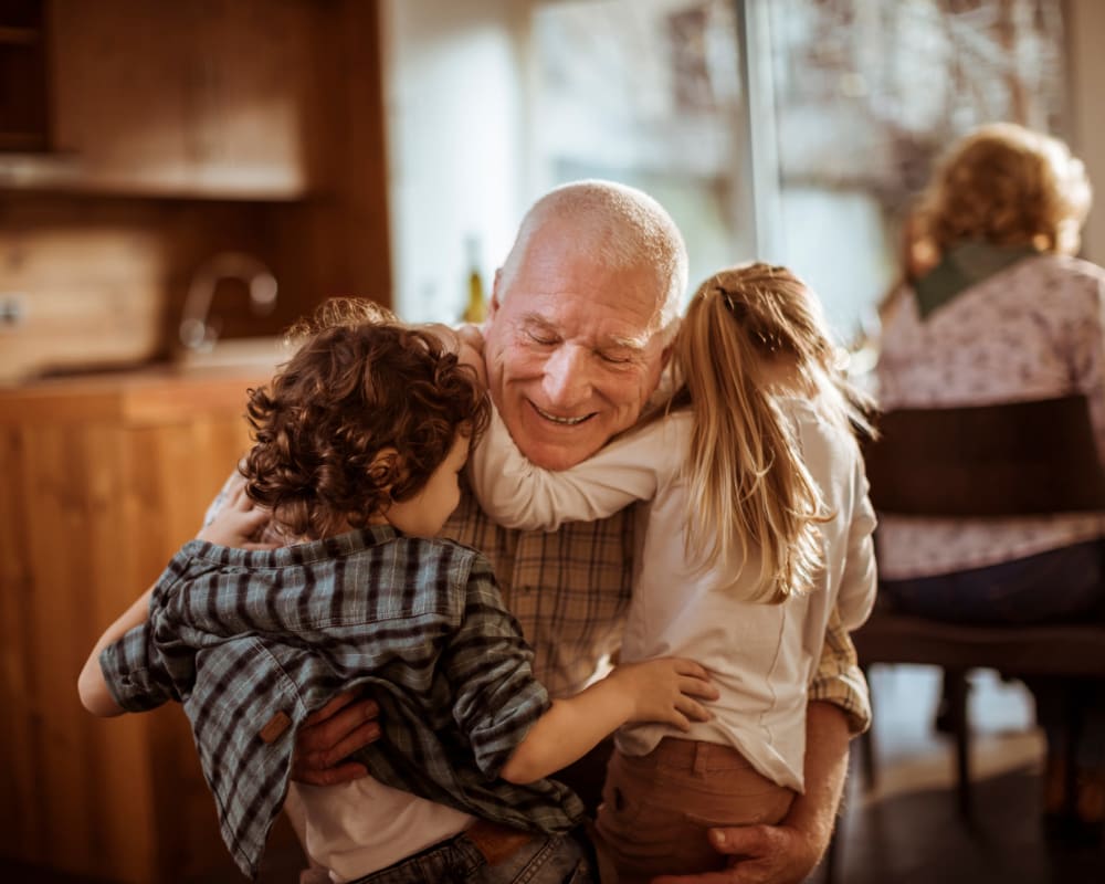 A resident hugging his grandchildren at Welbrook Grand Montecito in Las Vegas, Nevada