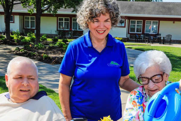residents outside with a caretaker in the garden at Chesterfield in Chesterfield, MO