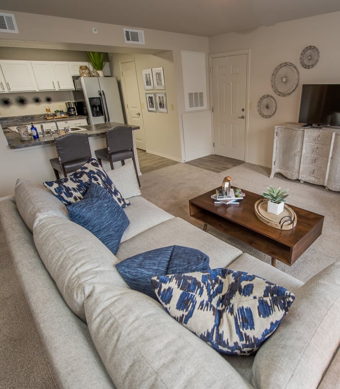 Carpeted living room and kitchen bar at Scissortail Crossing Apartments in Broken Arrow, Oklahoma