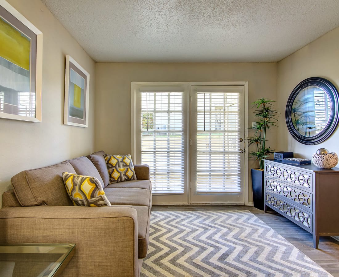 Furnished living room with doors out to a private patio at Canyon Grove in Grand Prairie, Texas