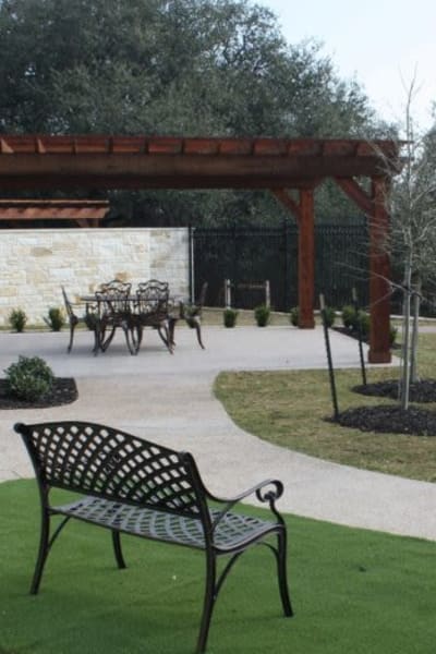 Courtyard with paved paths and benches at Quail Park of Granbury in Granbury, Texas