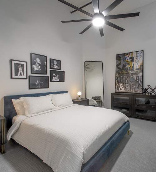 Modern bedroom with stylish decor and ample light at American Can Apartments in New Orleans, Louisiana