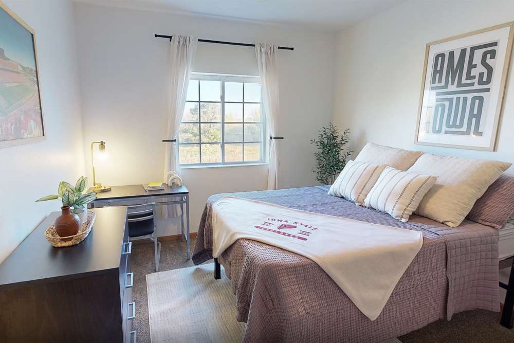 Bedroom with desk and dresser at The Landing Ames in Ames, Iowa