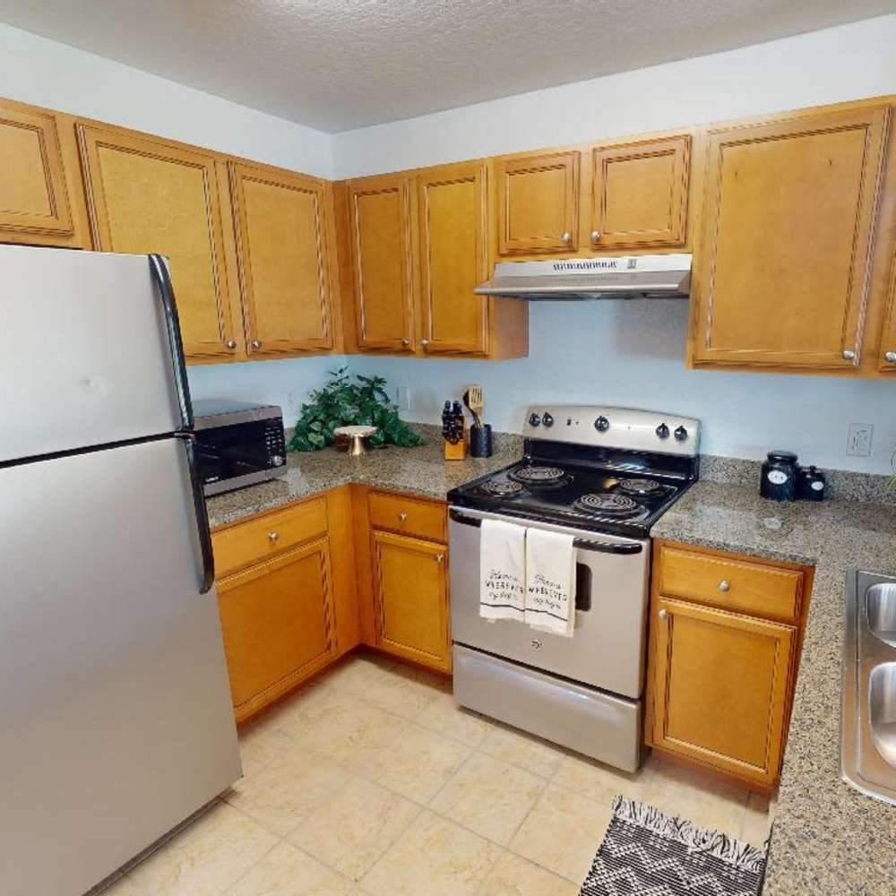 A spacious kitchen with wooden cabinets at The Reserve at Brookhaven in Palm Coast, Florida