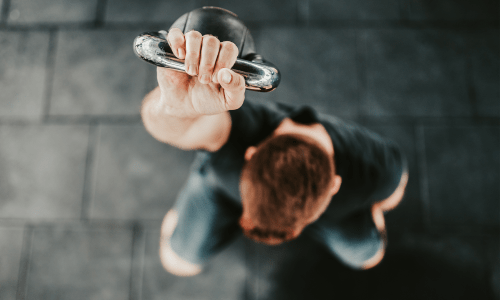 An exterior view of a resident holding a weightlifting equipment at Vestara 72 in Papillion, Nebraska