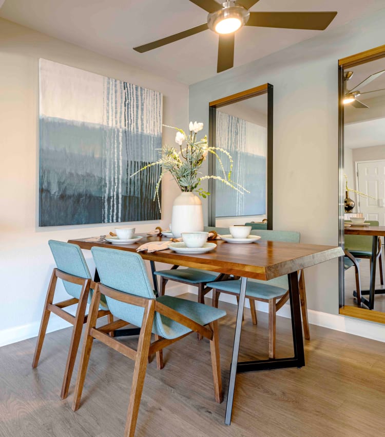 Open-concept living area with a ceiling fan over the dining area next to the kitchen in a model home at Sofi Berryessa in San Jose, California