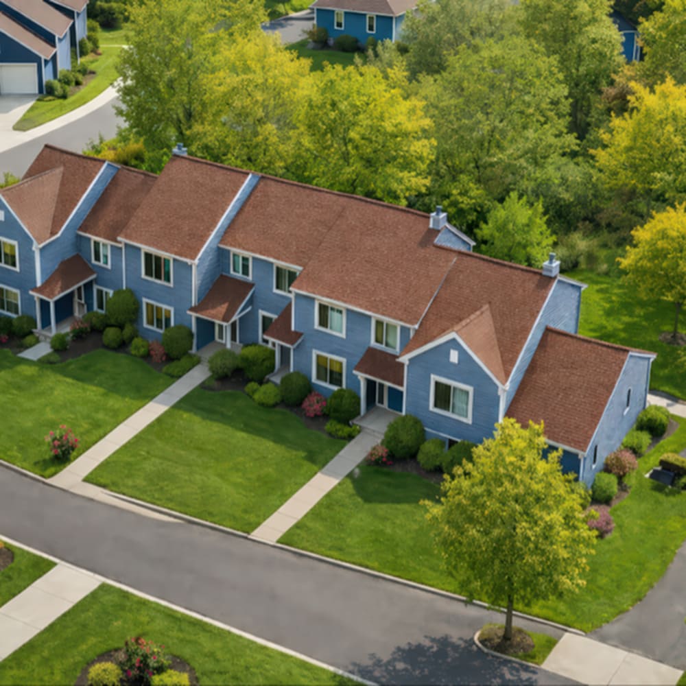 Lush landscaping with blue townhomes at 83 West Townhomes in West Bloomfield Township, Michigan