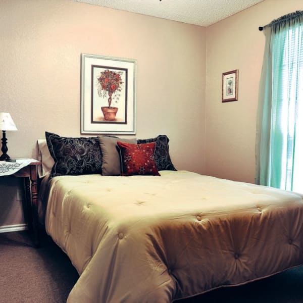 Furnished bedroom with a large bed inside a cottage at Quail Park of Granbury in Granbury, Texas