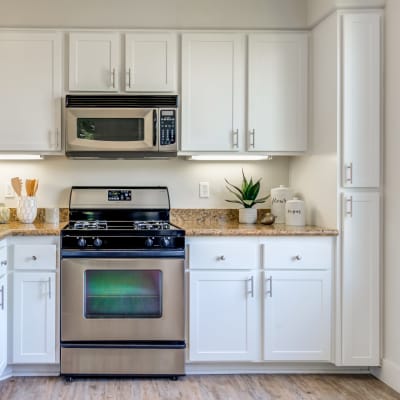 Modern kitchen with stainless-steel appliances in a model home at Sofi Shadowridge in Vista, California