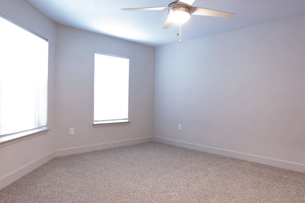 Modern bedroom with ceiling fan and large window at Villas At Mount Zion in Stockbridge, Georgia