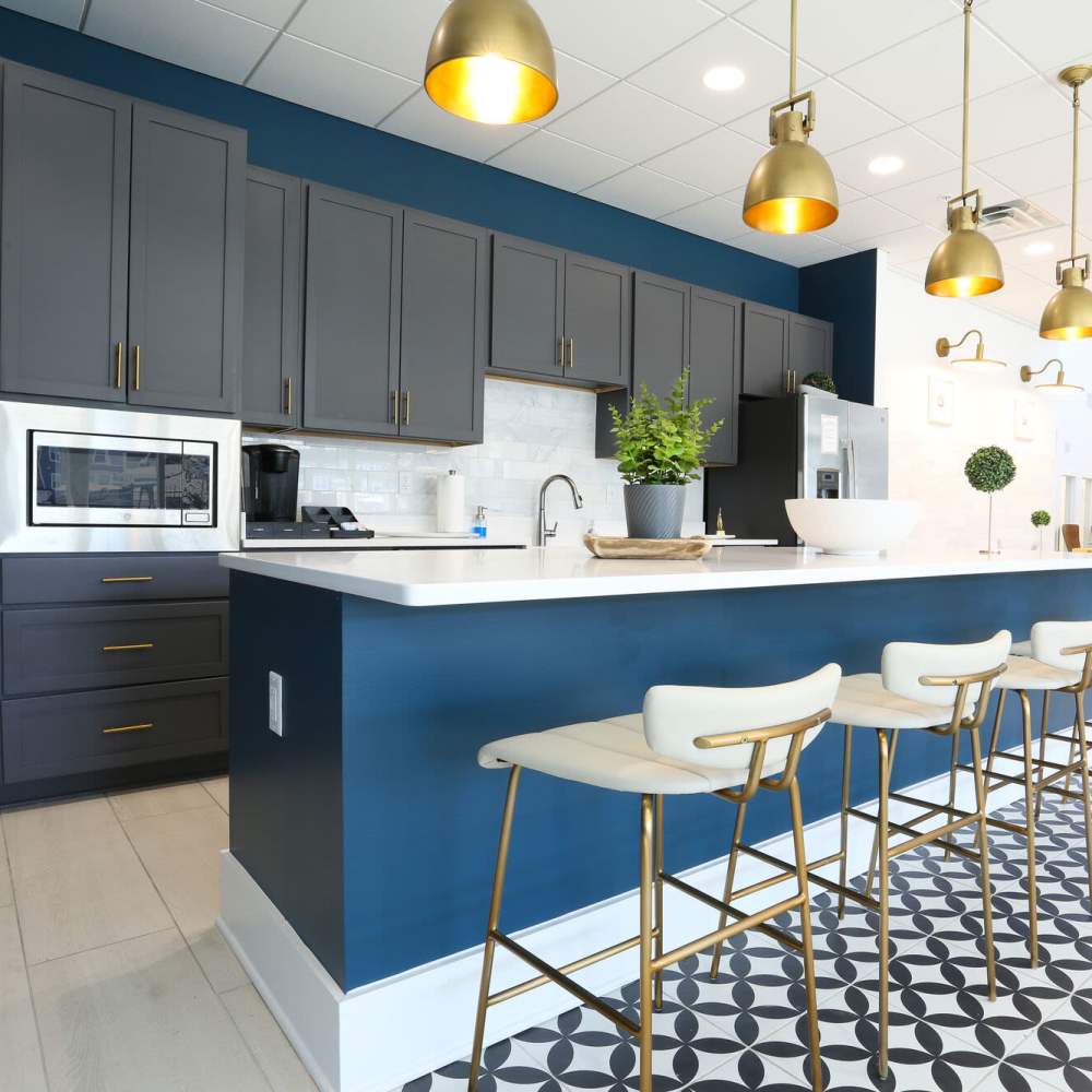 Modern kitchen with granite countertops and bar seating at The Apartments At Kelton Station in Williamsburg, Virginia