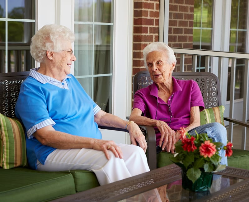 Two residents sitting outside and talking at Deer Crest Senior Living in Red Wing, Minnesota