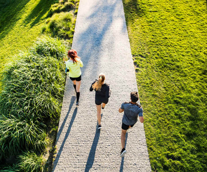 A group of friends running through a park near Ascent Apartment Homes in Asheville, North Carolina